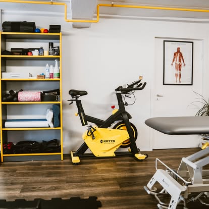 Rower treningowy i regał ze sprzętem rehabilitacyjnym